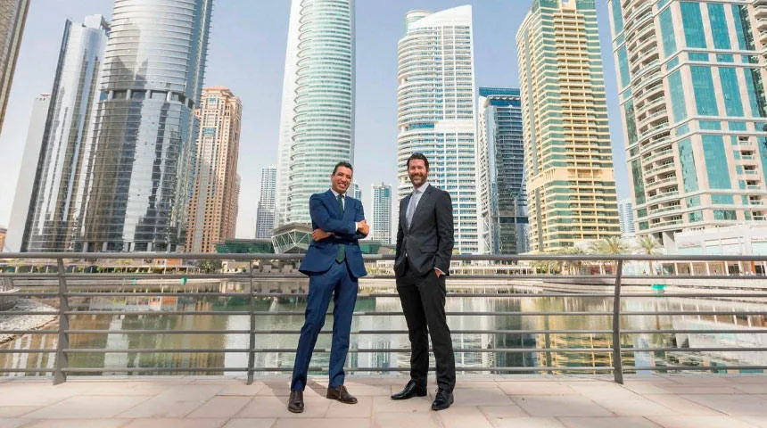 Two professional property investment consultants standing at Dubai Marina towers